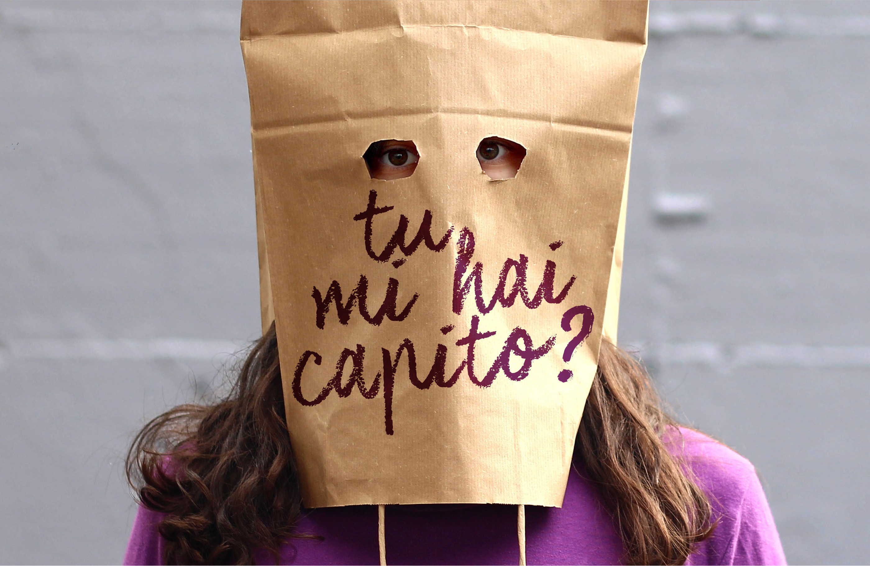 foto di una ragazza con una maschera di carta che porta la scritta: tu mi hai capito?
